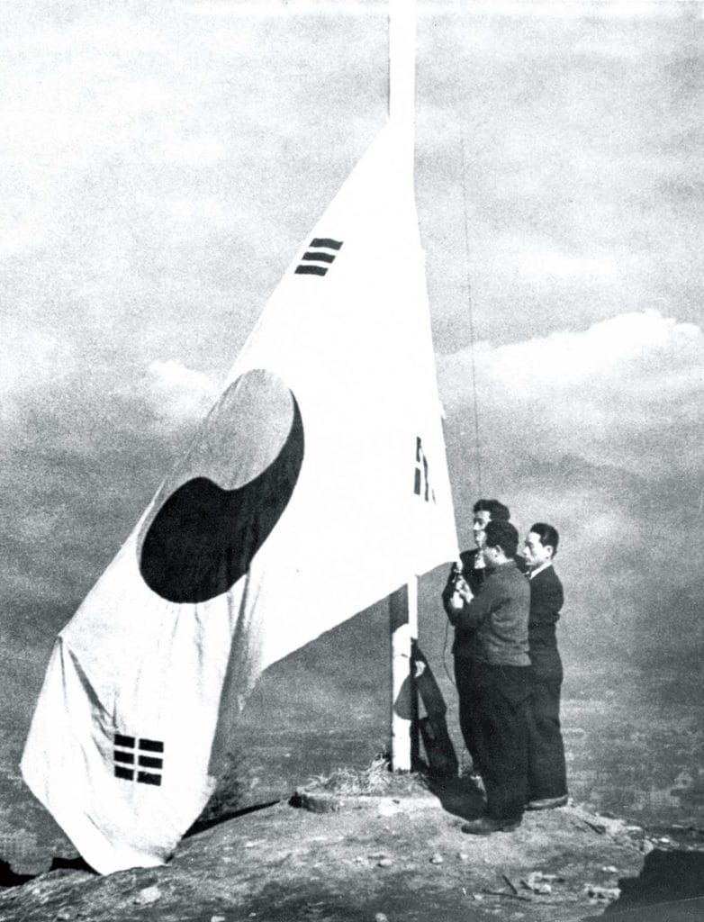 The Korean flag is raised atop Namsan, a hill in the center of Seoul, celebrating Korea’s newly won independence