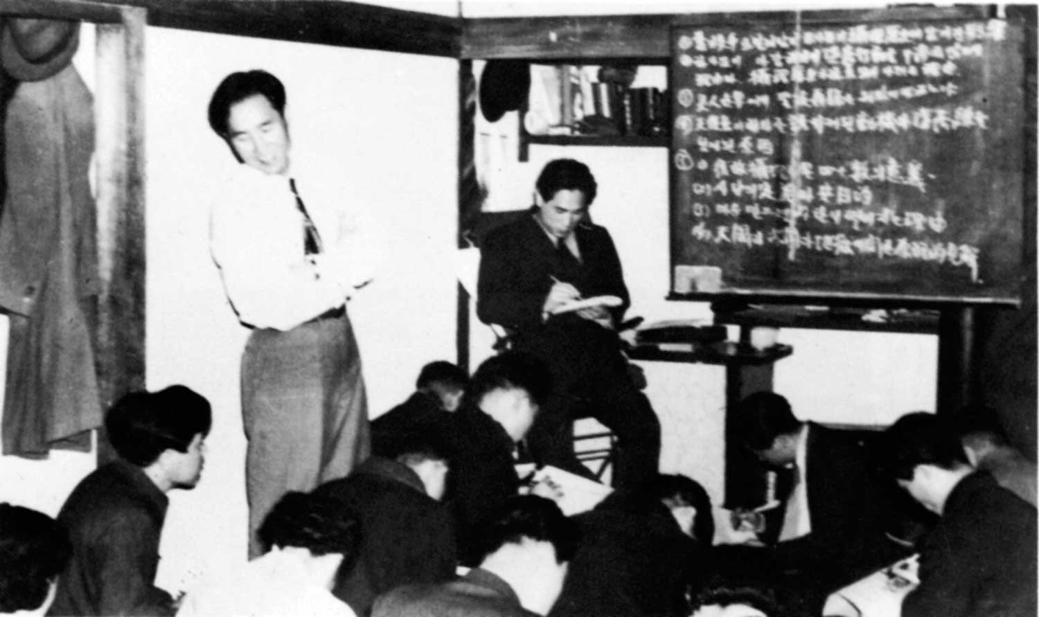 Father (standing) conducting a Divine Principle test at the Heung-in Dong church in Seoul, our headquarters in early 1955, on March 30. Seated on the chair is Rev. Eu Hyo-won.