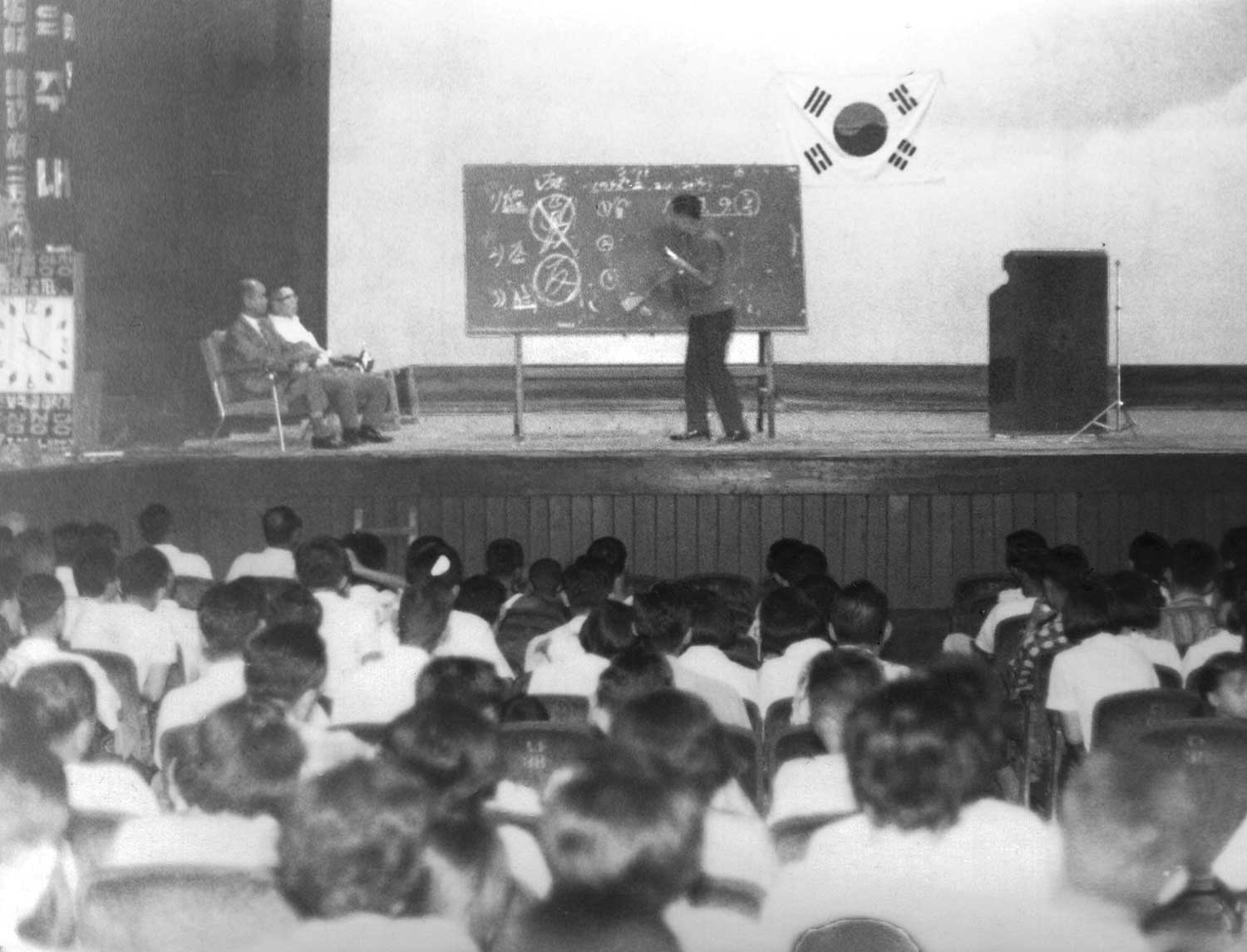A lecturer teaches Divine Principle to public sector workers and other citizens of the town of Euijeongbu, just north of Seoul, in August 1969