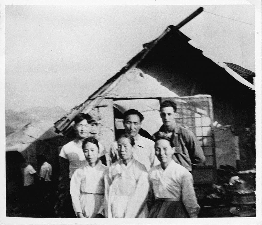In front of the hut are back, left to right, Kim Won-pil
