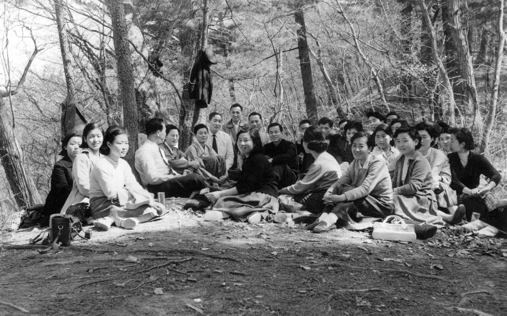 True Father, leaning against a tree, with members at an outdoor service in 1961