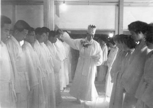 True Father sprinkling holy water on the thirty-three couples